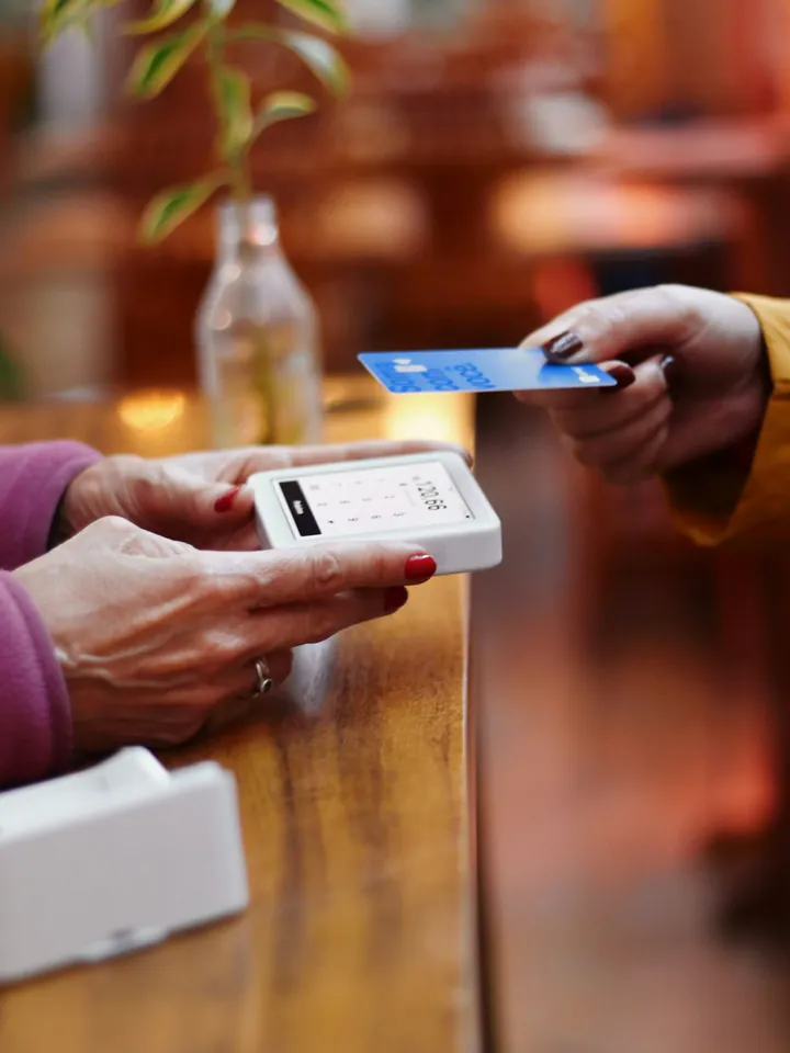 Cliente pagando com cartão na maquininha de um comércio (foto ilustrativa)